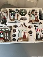 Porcelain Christmas village set with five houses arranged in protective styrofoam, showing overall collection and arrangement in the box.