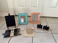 All items arranged on floor: 2 picture frames, 4 chalkboard easels of different sizes, and 1 burlap banner pack.