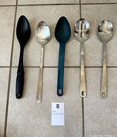 Photo of five serving spoons and ladle including slotted spoon, rubber and metal spoons
