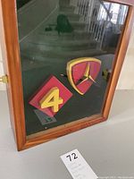 Front view of the shadow box showing two mounted insignias inside glass panel.