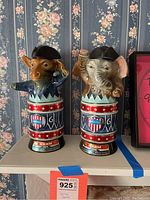 Front view of the Republican elephant and Democrat donkey Jim Beam decanter bottles on a shelf against floral wallpaper.