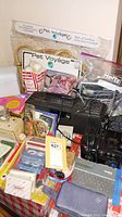 Wide view showing radios, pet bag, playing cards, cat clocks, and key chains on checkered tablecloth