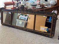 Full front view of three connected mirror panels in a single ornate frame.