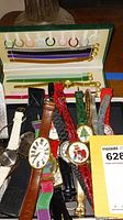 Multiple watches arranged in case with colorful fabric bands and gold buckle attachments