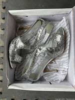 Pair of silver glitter Aldo high heel shoes with stiletto heels in original Aldo box lined with branded tissue paper.