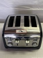 Front view of vintage Black & Decker 4-slice stainless steel bread toaster showing dual sliders and knobs on front panel.