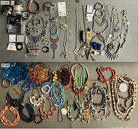 Overview of mixed costume jewelry spread on table, including necklaces, bracelets, earrings, pins, and brooches.
