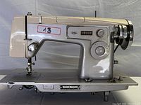 Side view showing the full Kenmore sewing machine body with mechanical handwheel, stitch length dial and needle area.
