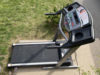 Side and elevated angle photo showing the treadmill deck and belt, metal frame, and control console.