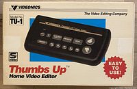 Front view of the original box showing the Videonics Thumbs Up Home Video Editor with model number TU-1 and product image on top, indicating product branding and usage as a home video editor device.