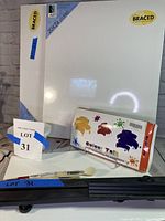 Photo showing 4 braced canvases, Colour Talk paint by number kit box, brushes and easel base
