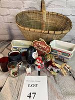 Wicker basket, 4 ceramic Christmas mini loaf pans, 3 votive candle holders, 4 Christmas figurines, and Happy Holidays plaque arranged on wooden surface.