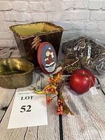 Overview of lot showing pine cones in plastic bag, square brown vase with vine rim, metallic tin bake pan, angel plaque, woven egg basket with fall berries, red apple, and decorative gourd clearly visible