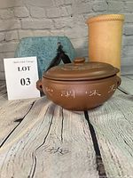 Photo showing the three items: tall tan clay vase, blue oval feathered vase, and brown pottery bun warmer with lid