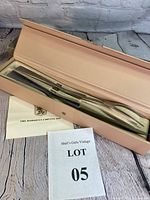 Overview photo of the Damacus 2-piece stainless steel carving set inside original tan leather box with design on the cover. Includes informational insert showing brand name and lot number.