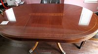 Full view of Thomasville wooden dining/party table top showing polished surface with decorative inlay and a removable leaf section.