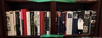 Shelf of various hard and soft cover books with spines showing titles related to biographies and historical figures
