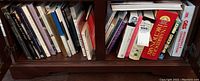 Books on wooden shelf including historical, art, and literary titles