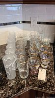 Photo showing a variety of etched glasses including frosted floral glasses and clear with gold rim