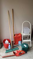 Full lot showing all items: step ladder, jerry can, rakes, broom, compost bin, cleaning supplies, and green storage box.