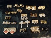 Top view group photo showing 20 pairs of assorted clip-on earrings arranged in rows on a black background
