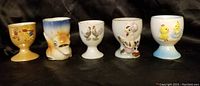 Photo of five egg cups with various animal and illustrated designs