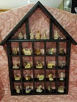 Full view of the wooden Knick Knac shelf with 25 miniature figurine-shaped teapots displayed in compartments.