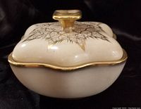 Front angle showing cream porcelain lidded dish with gold trim and decorative crackle gold pattern on lid.
