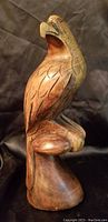 Wooden eagle sculpture angled view showing carved feathers and open beak detail
