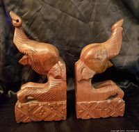 Pair of wooden elephant carved bookends, showing side view of each bookend with detailed carvings and medium brown finish.