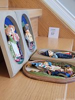 Side angle showing 3D wood-framed pictures on stairs, featuring colorful children figures and vintage clothing detail