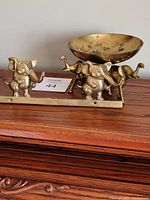 Photo showing the brass wall hanger with three elephant figures and the vintage brass bowl supported by three elephant figures