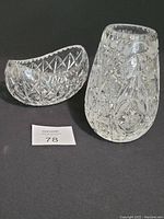 Crystal vase and boat-shaped crystal bowl shown together on a dark surface, highlighting their thick walls and decorative cut patterns.