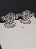 Pair of vintage glass candle holders with bubble design and silver overlay base on black background.