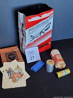 Photo showing Hama film-safe lead lined bag with vintage Agfa film envelope, film rolls, metal and plastic film canisters, small blue plastic case, and vintage cards with envelopes.