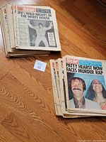 Two stacks of vintage Star and National Star magazines laid out on wood floor, showing various front covers with bold headlines and images from the 1970s.