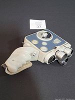 Photo showing the Euming C3-M 8mm movie camera with original pistol grip handle attached, front and top side view.