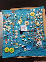 Full view of vintage pin collection displayed on blue cloth