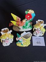 Four porcelain mini vases including two wall-mountable with yellow birds, a dwarf attached vase, and a bird with flower figurine.