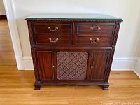 Front view of the antique Philips radio cabinet highlighting the wood drawers, storage compartments and central mesh-covered speaker panel.