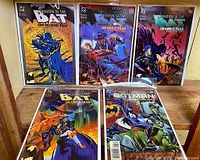 Photo of five Batman Shadow of the Bat comic books, issues #11, #16, #17, #18 and Annual #4, arranged on a wooden surface, all in plastic bags with boards.
