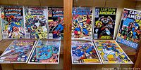 Full lot view showing 10 Captain America issues arranged in two rows on wood shelf, bagged and boarded.