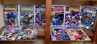 Full set of 10 Doctor Strange comic books displayed on a wooden shelf, showing cover art and condition.