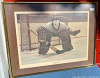 Framed print showing hockey goalie in vintage gear in front of net under glare-resistant acrylic.