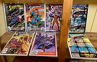 Seven Superman comic books from 1986-1990 displayed upright and flat, showing cover art and condition.