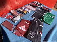 Overview of vintage NHL flags laid out on a towel showing various folded flags in different colors and designs.