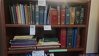 Shelf with multiple older hardback and spiral-bound medical books