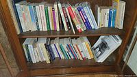 Books arranged on wooden shelves showing titles related to nutrition, health, and wellness.
