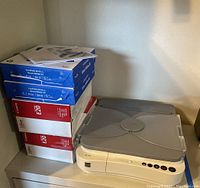 Overall view of the Canon copier alongside two reams of Hammermill Great White 30 copy paper and two boxes of Canon E20 ink cartridges.