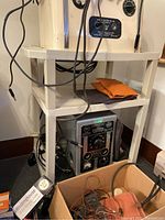 Two-sided view of plastic utility carts holding electronic and miscellaneous items, showing brand and condition of equipment.